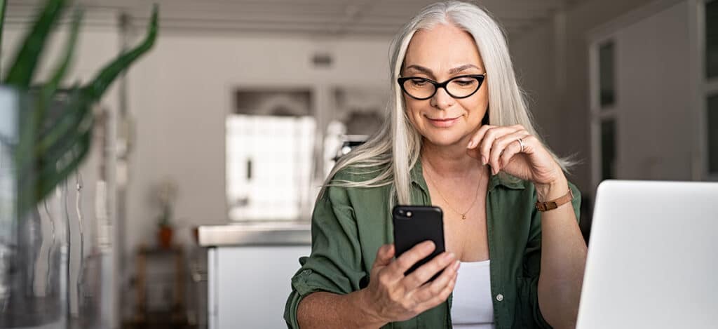 a woman connecting her hearing aids to her smart phone