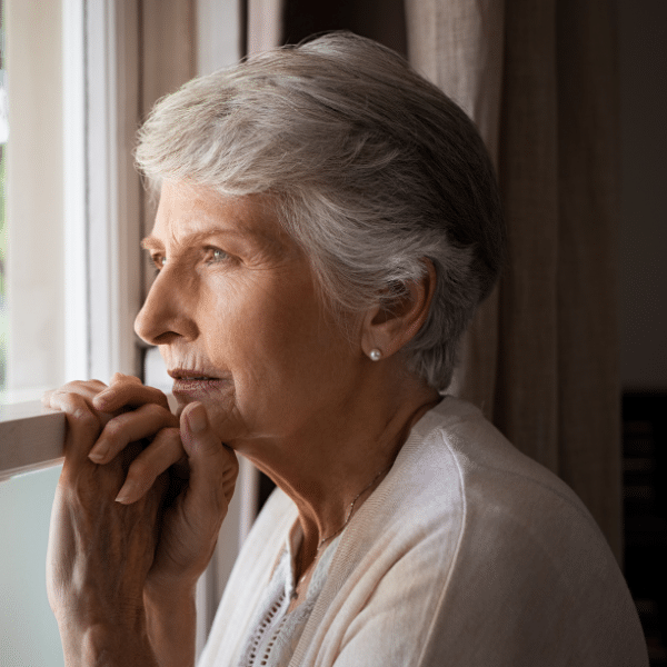 older lady looking wistfully out of a window