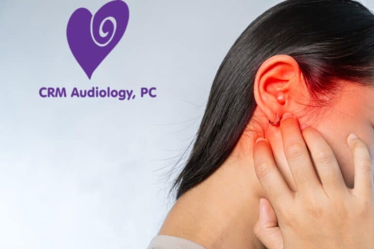 woman holding her glowing red ear