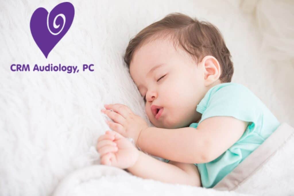 a baby sleeping in a bed